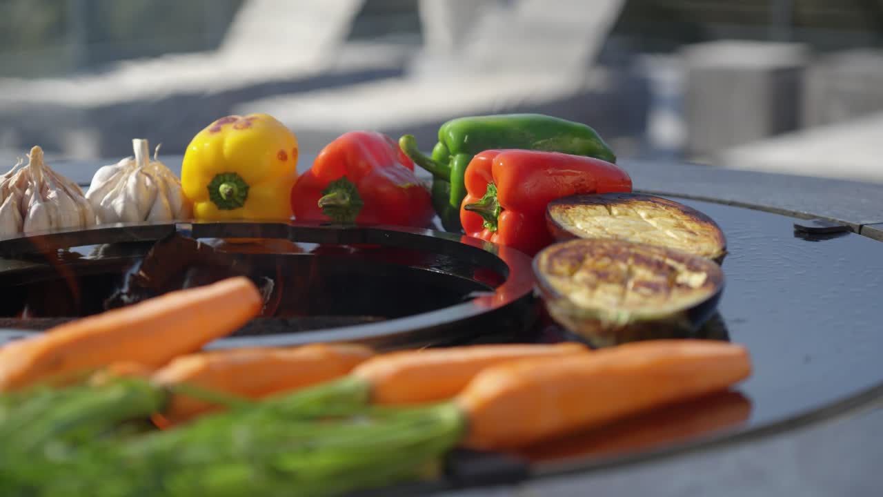 Colorful array of fresh vegetables grilling on a circular outdoor barbecue grill