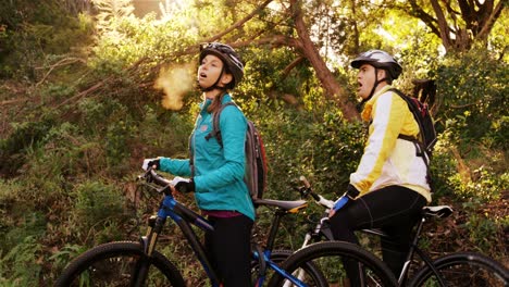 exhausted mountain biking couple taking a break