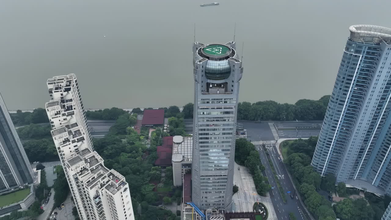 Drone view of helicopter pad helipad on the roof of a skyscraper landmark building in downtown with cityscape view on sunny day