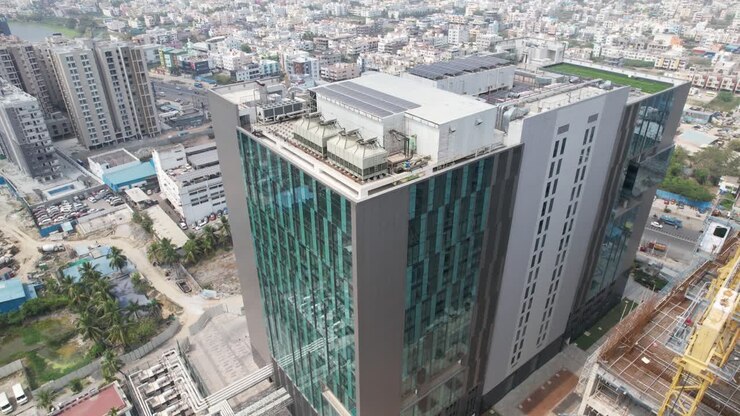 Aerial cinematic video showcasing a commercial highrise building's installation of sustainable solar panels for partial energy consumption