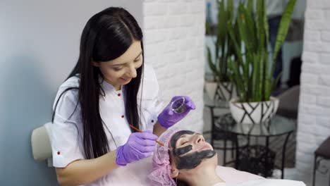 cleansing face mask. woman receiving cosmetic procedure in beauty salon.