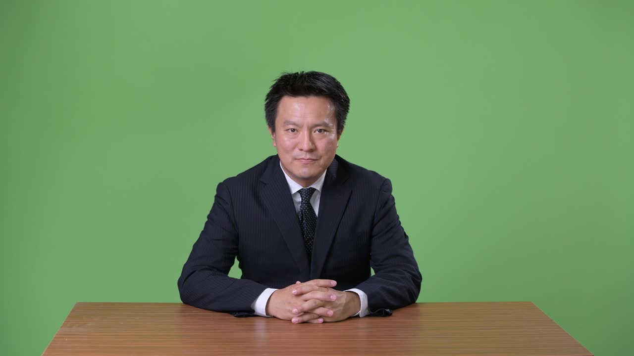 녹색 배경에 성숙한 일본 사업가