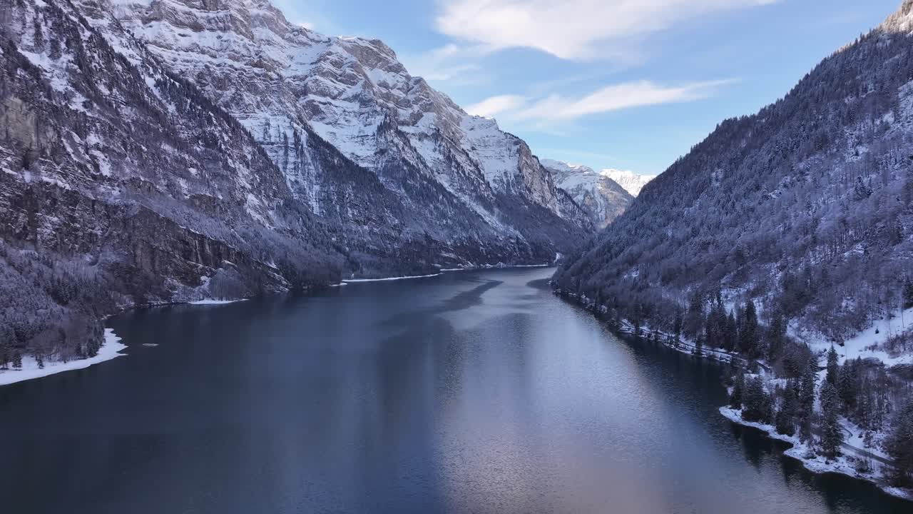 Snowy Klöntalersee in Glarus, Switzerland, surrounded by majestic alpine peaks