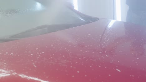 car washing cleaning with foam and high pressured water. red car