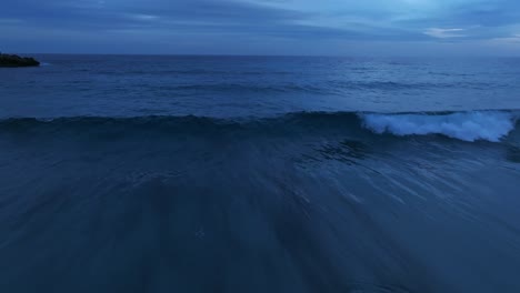 Nahaufnahme-Von-Strandwellen,-Die-Nach-Sonnenuntergang-Brechen,-Nahaufnahme-Einer-Luftdrohne-Aus-Der-Skyline-In-Der-Abenddämmerung