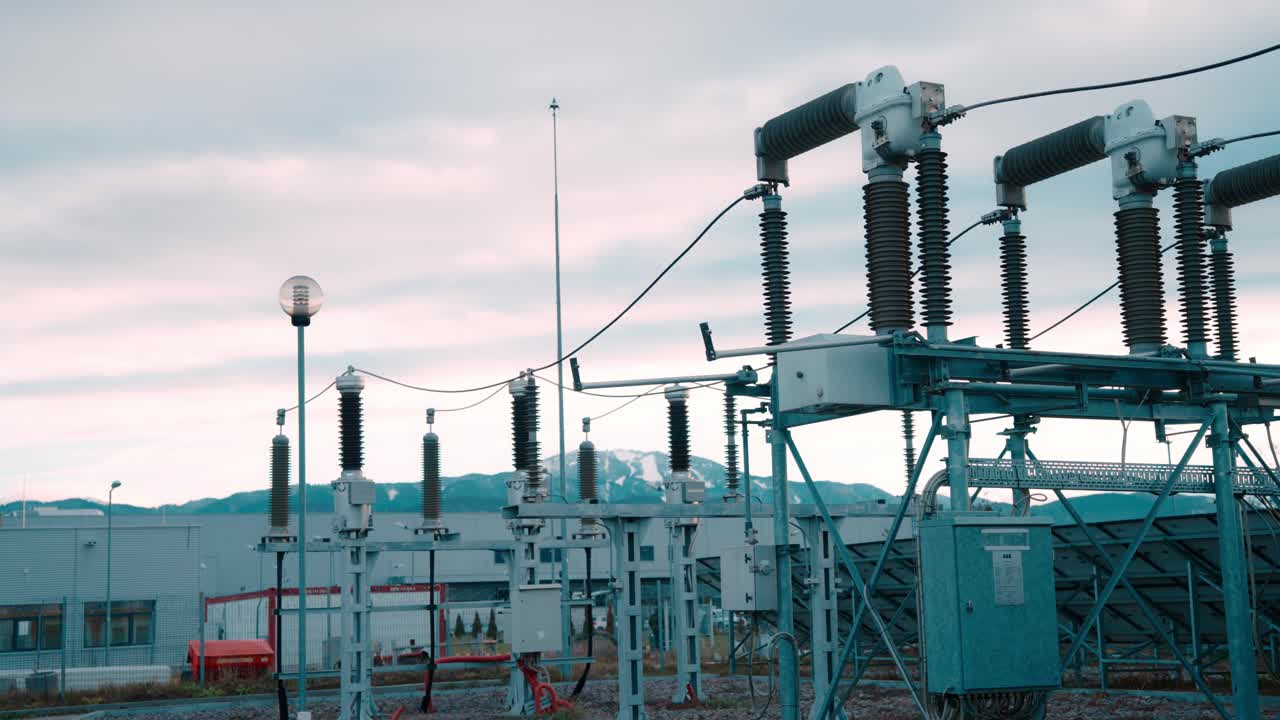 Electrical station with transformers under cloudy sky, industrial setting