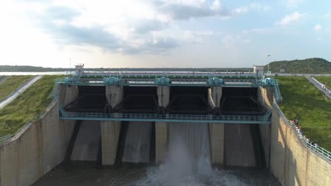 Filmische-Luftaufnahme,-Verkleinerte-Aufnahme-Des-Wasserreservoirs---Aufnahme-Des-Staudamms---Wasser,-Das-An-Heißen-Sonnigen-Tagen-Aus-Den-Toren-Des-Reservoirs-Freigesetzt-Wird