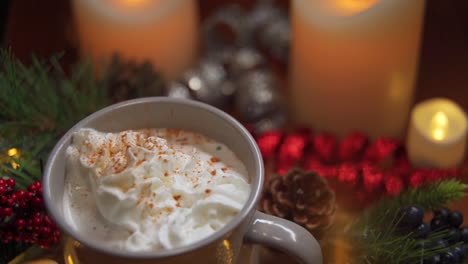 a looped clip of cinnamon sprinkles falling on whip cream in a cup of holiday hot cocoa