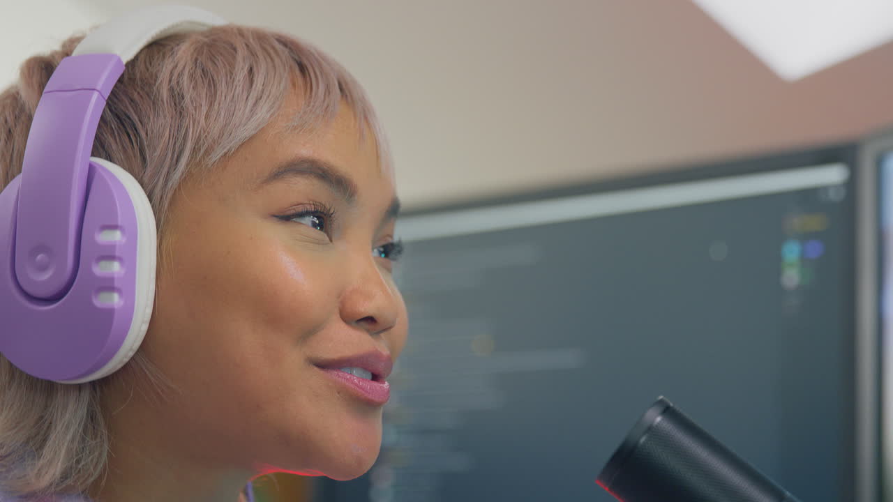 mujer jugando en casa sentada en el escritorio con auriculares para transmisión en vivo