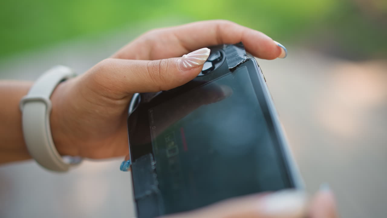 Primer plano de una mano retirando con cuidado un protector de pantalla, con un banco de parque de fondo, un smartwatch visible en la muñeca, restos de adhesivo y polvo en los dedos, enfoque macro sobre el cristal reflectante, movimiento lento y deliberado