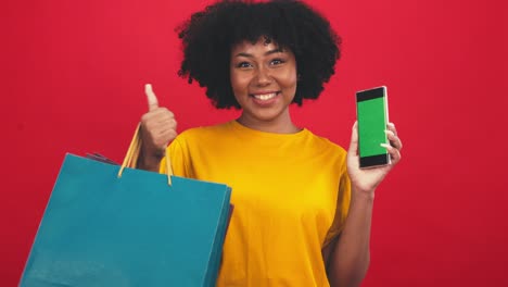 feliz mujer africana sonriente sosteniendo anillo de goma flamenco y disfrutando de sus vacaciones de verano.joven mujer afroamericana aislada en fondo rojo de color en vacaciones con viajes.