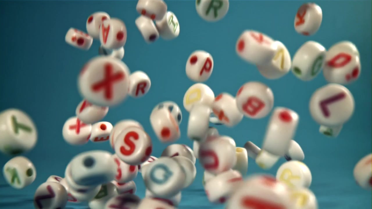 Perline colorate con lettere dell'alfabeto che cadono al rallentatore