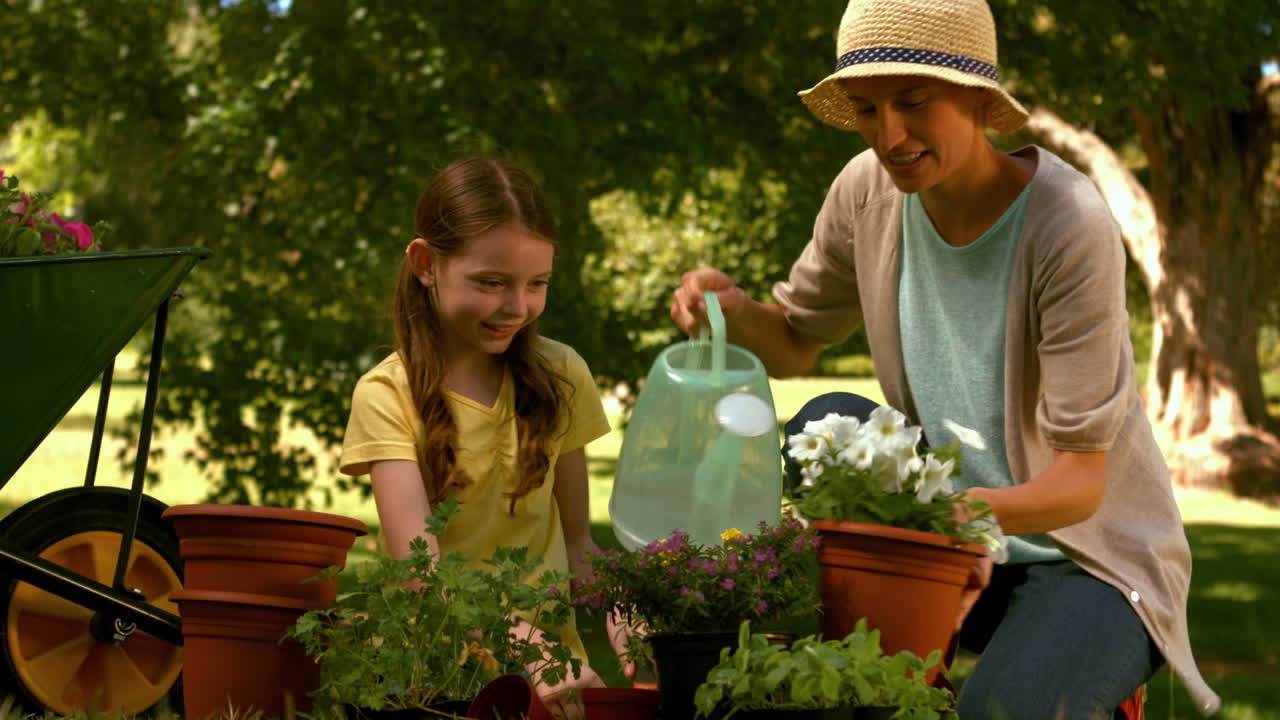 어머니 와 딸 이 함께 정원 을 꾸리고 있다