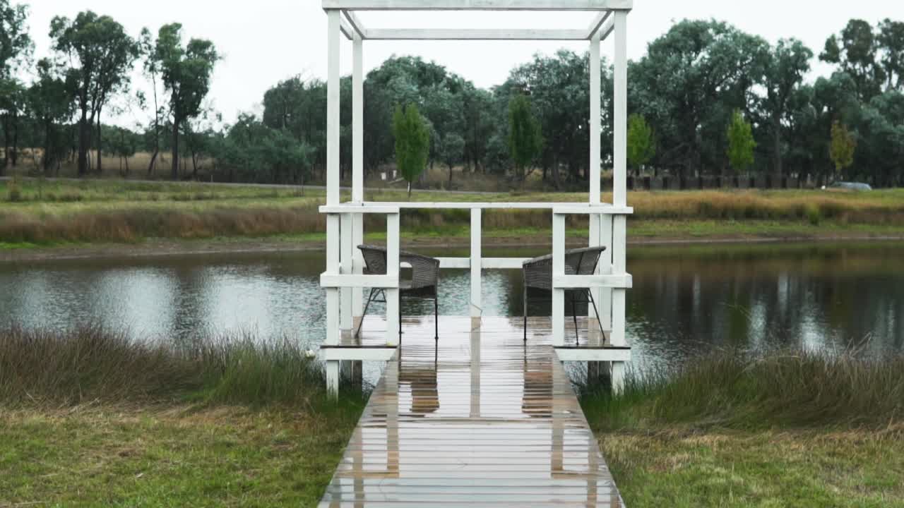 고요한 호수에 빈 의자가 있는 나무 도크 - 와이드 샷