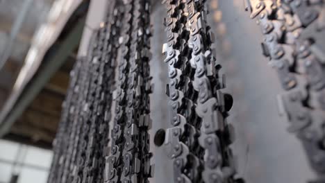 metal chainsaw chains hanging on side of wall, lumber mill