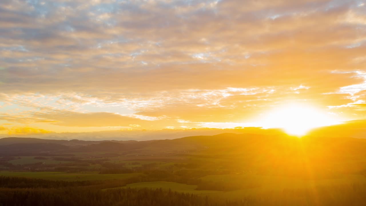 Beautiful altocumulus clouds rolling over the peaceful mountain village of Poland during sunset - time lapse