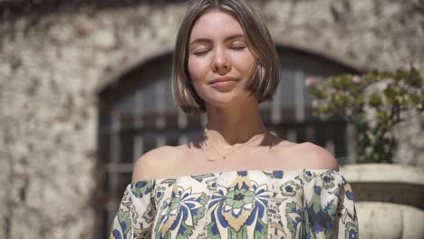 Beautiful-Woman-Looking-Into-The-Camera,-Young-Woman-Standing-In-Front-Of-An-Old-Wall