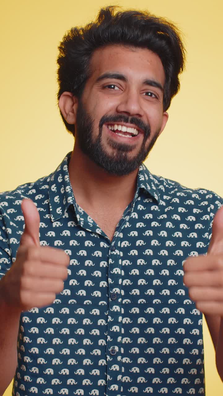 Indian young man raises thumbs up agrees or gives positive reply recommends advertisement likes good