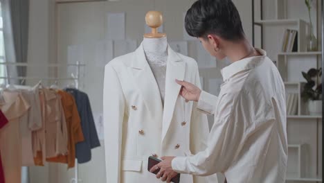young asian man fashion designer take photo of clothes on mannequin model