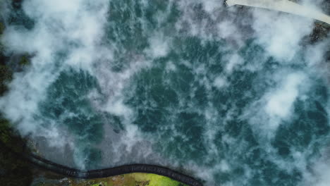 vapor saliendo de la piscina termal en el parque kuirau, rotorua, nueva zelanda - vista aérea de arriba hacia abajo