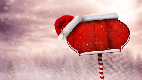 Animation-of-snow-falling-and-north-pole-sign-with-santa-hat-over-winter-scenery