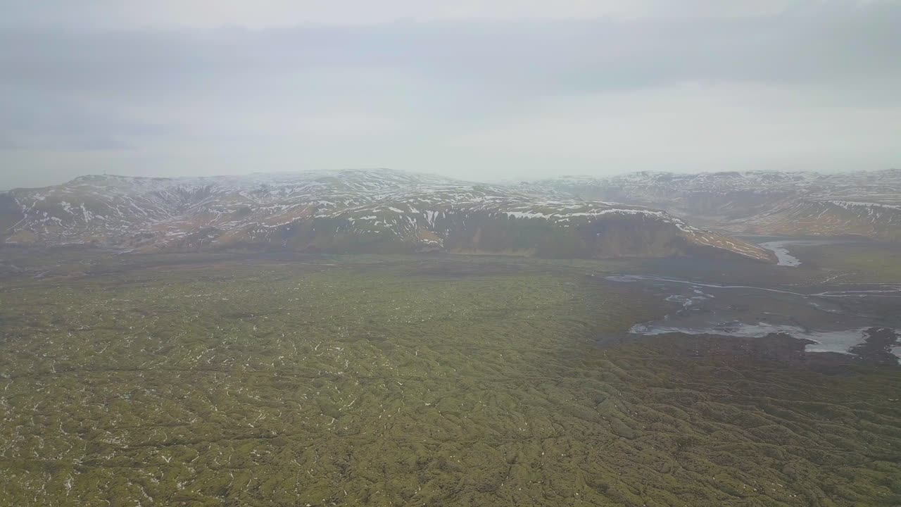 Aerial shot high up in the sky overlooking Icelandic mountains and rivers