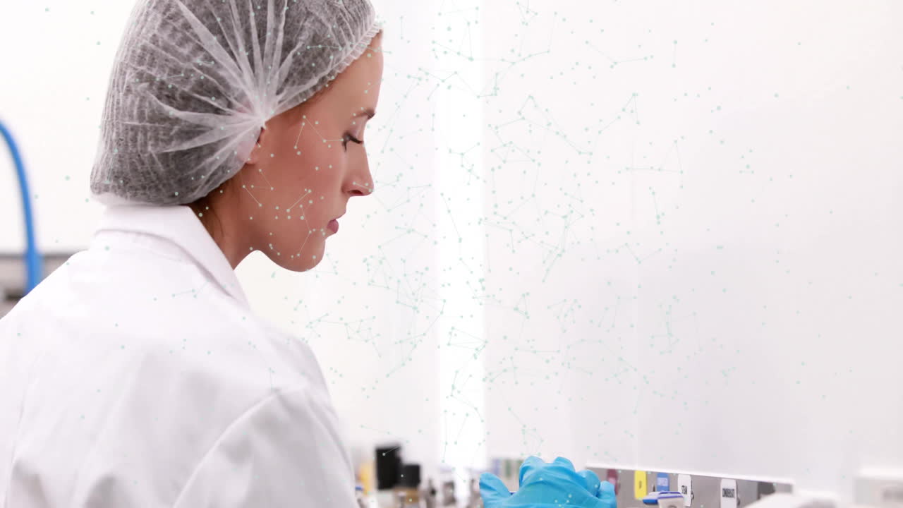 En laboratoire, un scientifique en blouse et charlotte travaillant avec une superposition d'animation.