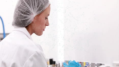 in lab, scientist in lab coat and hairnet working with animation overlay