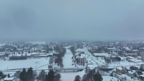 aéreo de volar sobre una pequeña ciudad durante la tormenta de nieve