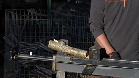 Log-being-crashed-in-a-special-wood-cutting-machine,-adult-male-preparing-for-cold-winter