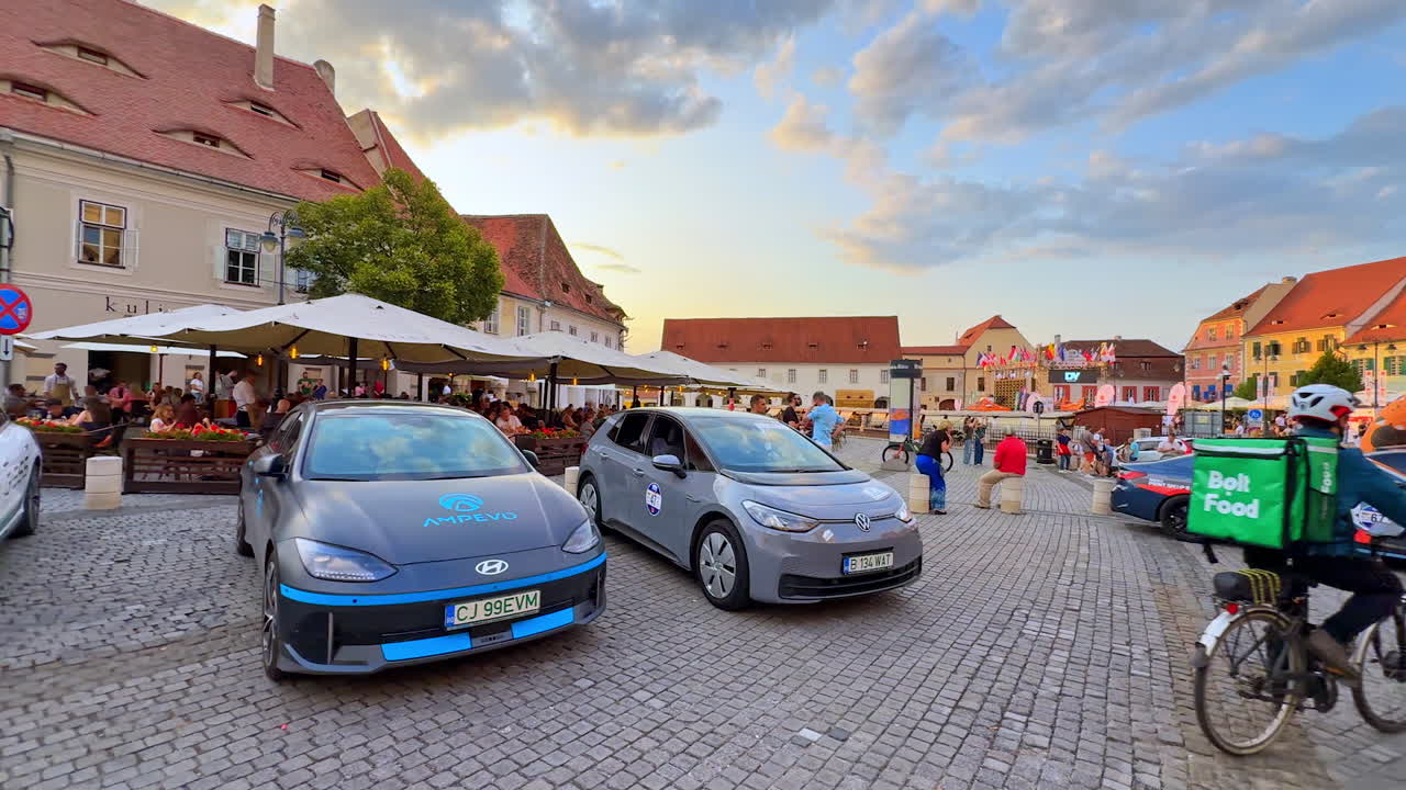 Sibiu, Romania, 17 July 2025: Racing cars in Sibiu square. Modern cars on display with people walking around in Sibiu, Romania