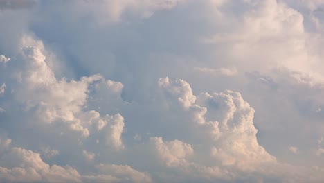 time lapse, cloudscape view of white fluffy clouds moving in the wind over a blue sky