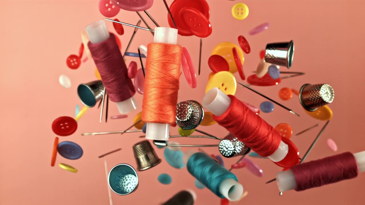 Colorful Sewing Supplies Floating Against a Pink Background