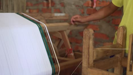 indian labor working controlling a weaving wooden mechanical machine in india