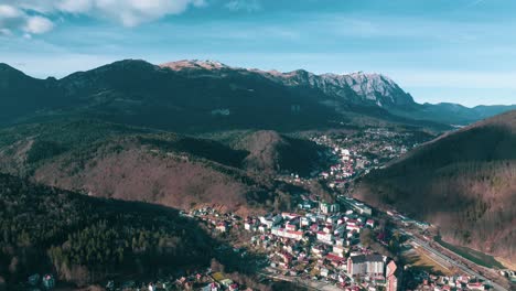 hiperlapso aéreo disparado sobre la ciudad de sinaia en el valle de las montañas con nubes voladoras