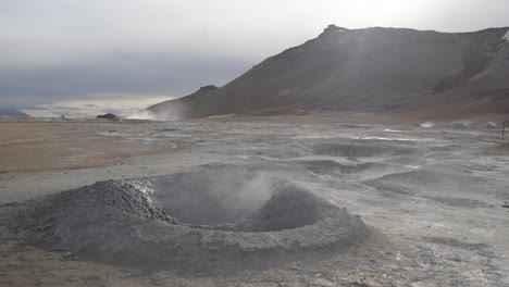 steam coming from small geothermal springs in volcanic landscape, iceland