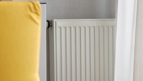 white radiator in a room with yellow pillow