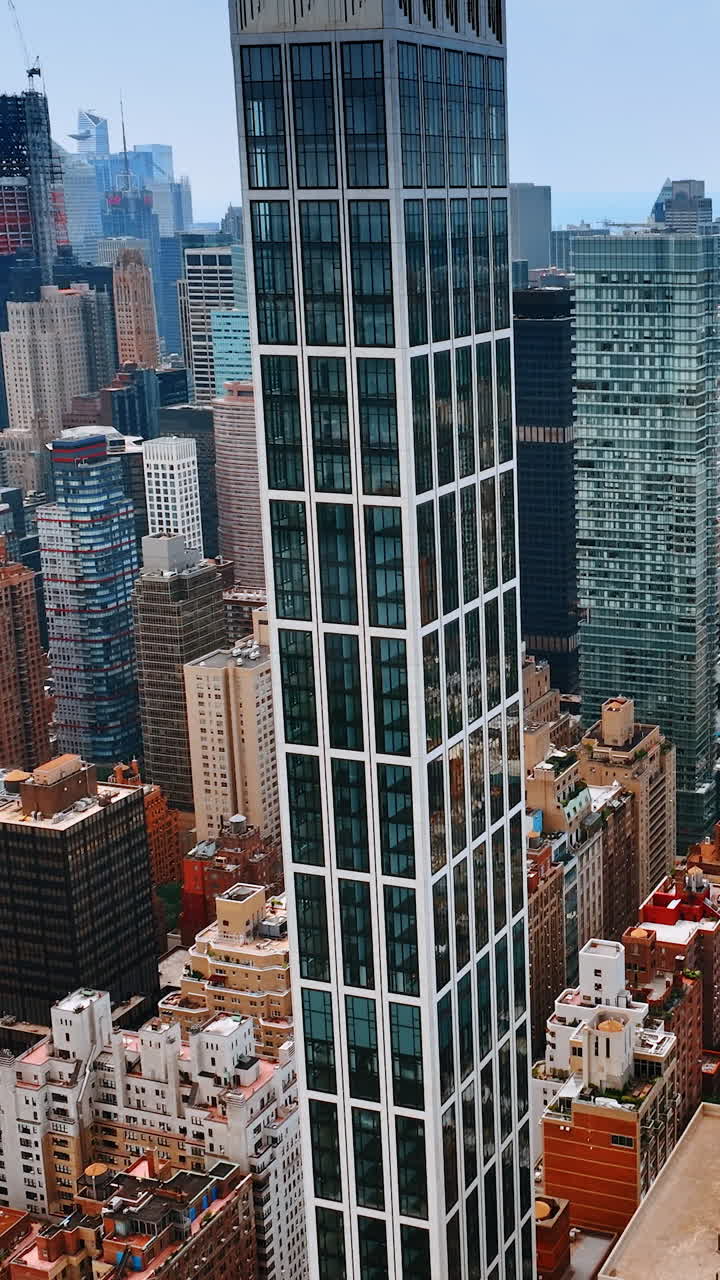 Descending footage above the stunning Manhattan skyscrapers at daytime. Sutton Tower building at foreground. New York from top. Vertical video