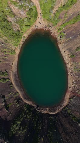rising drone shot reveals the kerid crater in iceland, vertical video.