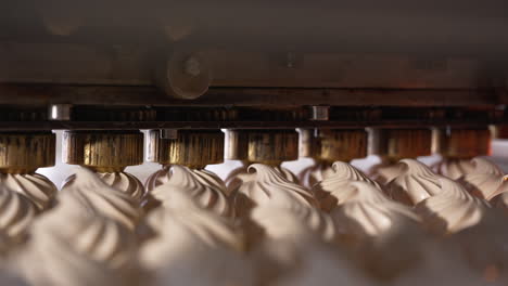 automated line with rotating nozzles producing vanilla marshmallows. close up. food factory concept.