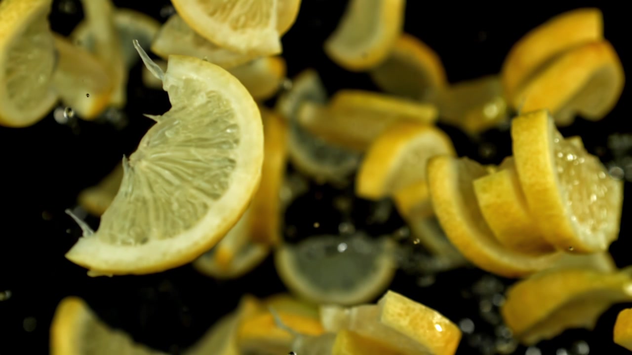 Super slow motion di fette di limone fresco che cadono con l'acqua