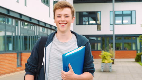 portrait of male student standing outside college building