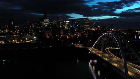 Aerial-drone-view-of-the-Edmonton-Walterdale-Bridge-over-the-North-Saskatchewan-River-during-a-summer-night-and-the-downtown-skyline-in-the-background