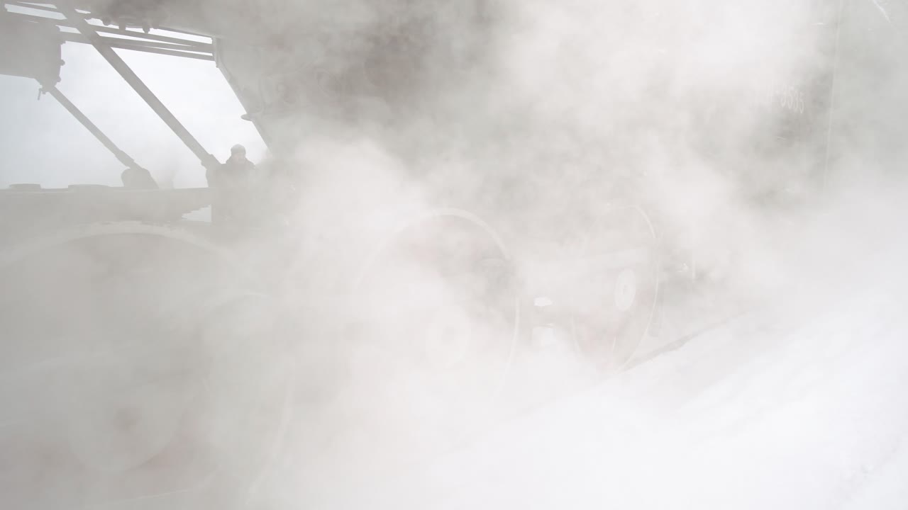 Locomotiva a vapore d'epoca che emette vapore in un inverno nevoso