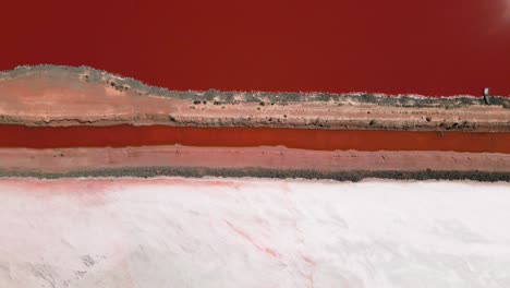 Arial-of-a-straight-path-through-a-white-and-red-salt-pan