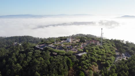 aerial view of a sanctuary on a hilltop surrounded by fog