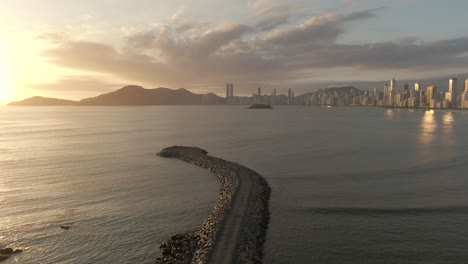 scenic sunset over the calm sea in molhe da barra norte in santa catarina, brazil