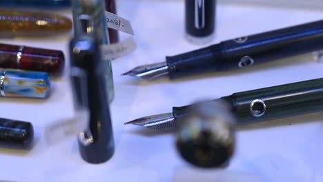 fountain pens are on display for sale in a pen shop, exploring the artistry of fountain pens