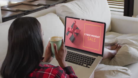 Mujer-Birracial-Usando-Laptop-En-Casa-Comprando-En-Línea-El-Día-De-Venta-Del-Lunes-Cibernético,-Cámara-Lenta