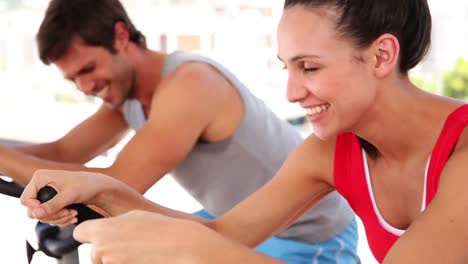 Fit-couple-working-out-on-exercise-bikes-